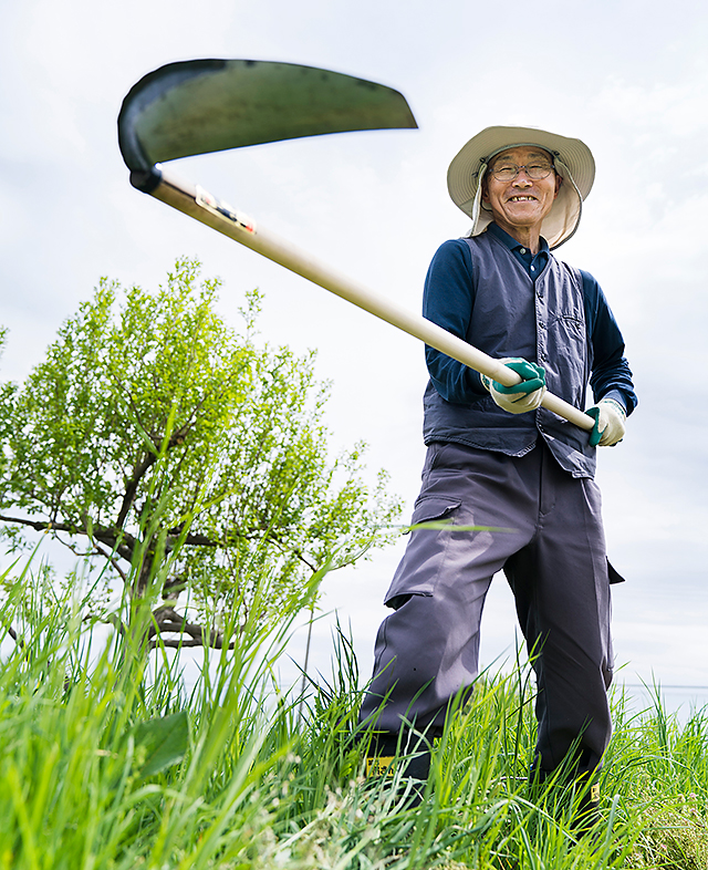 中川原敏雄さんは大鎌草刈りの名人。近頃は女性や自然農法に関心のある方を中心に大鎌が広がりつつある（黒澤義教撮影）